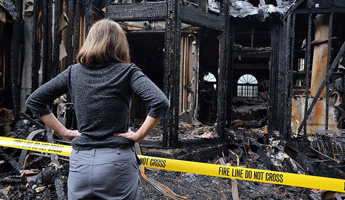 a person is inspecting fire damaged area