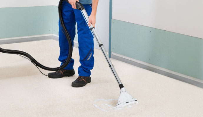 Expert cleaning carpet using equipment.