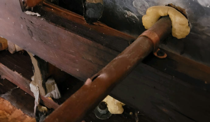 close-up view of a hole in metal water pipe